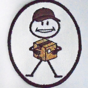 以下が含まれることがあります： 茶色の帽子をかぶって茶色の箱を持った棒人間の刺繍パッチ。棒人間は笑顔です。