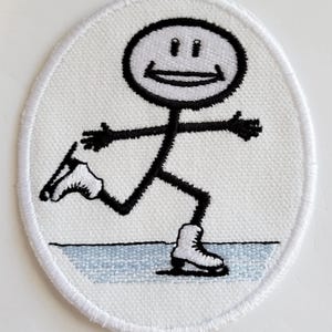 May include: White embroidered patch of a stick figure ice skating with a smiling face. The figure is wearing white skates and is on a blue ice surface.