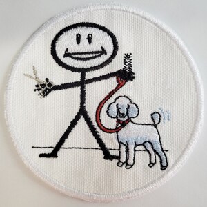 Puede incluir: Parche blanco bordado con una figura de palo que sostiene unas tijeras y un cepillo, paseando a un caniche blanco con una correa roja.