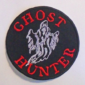 May include: A black and red embroidered patch with a white ghost and the text "Ghost Hunter".