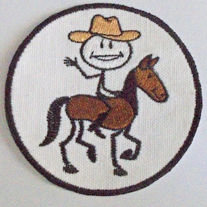 Puede incluir: Un parche bordado blanco con un caballo marrón y un vaquero de palo con un sombrero marrón. El vaquero está montando a caballo.