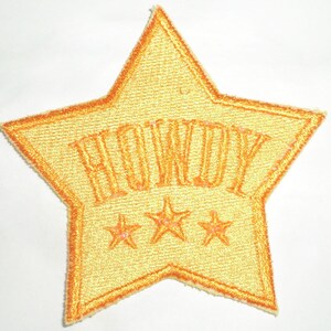 May include: A yellow star-shaped patch with the word "HOWDY" embroidered in orange and three smaller yellow stars below it.