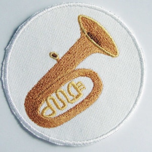 May include: A white circular patch with an embroidered gold tuba. The tuba is a brass instrument with a bell-shaped mouthpiece and a long, cylindrical body.