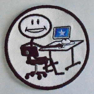 Peut inclure: Un patch brodé blanc représentant un bonhomme bâton assis à un bureau avec un ordinateur. Le bonhomme bâton sourit et l'écran de l'ordinateur affiche une étoile.