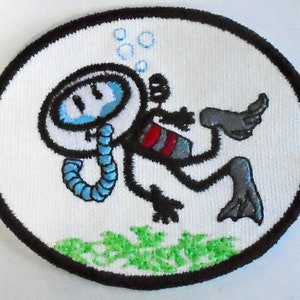 Könnte beinhalten: Ein weißer gestickter Aufnäher mit einem Cartoon-Taucherschwimmer, der einen Helm und Flossen trägt. Der Taucher ist von Blasen und Algen umgeben.