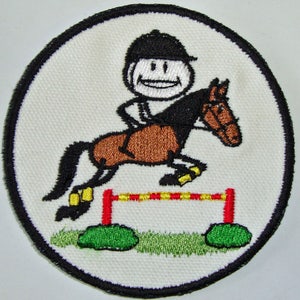 May include: Embroidered patch of a stick figure person riding a brown horse over a red and yellow fence. The horse is jumping over the fence and the person is smiling.