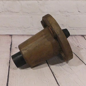 May include: A white ceramic mug with a black handle and the text "But First, Coffee" in a bold, black font. The mug is set against a blurred background, suggesting a cozy setting.