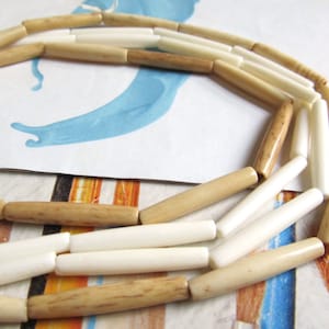 May include: A necklace made of alternating white and brown cylindrical beads. The beads are arranged in a circular pattern.