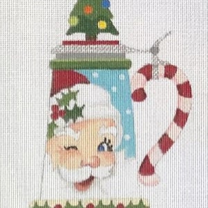 May include: A ceramic Christmas mug with a Santa Claus face, a green Christmas tree on top, and a candy cane handle. The mug has a blue and white background with white polka dots. The mug is decorated with a green holly sprig and red berries.