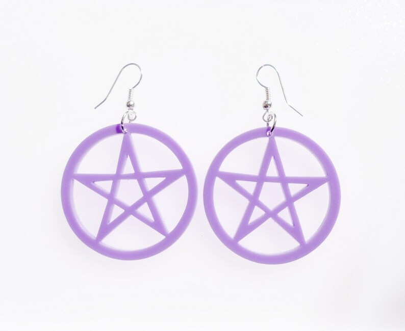 May include: A pair of purple earrings with a pentagram design. The earrings are made of acrylic and have silver hooks.