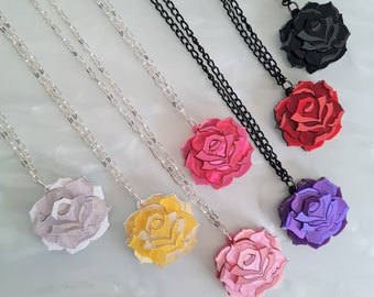 May include: Six necklaces with different colored rose pendants. The roses are layered and have a 3D effect. The necklaces are silver chains.