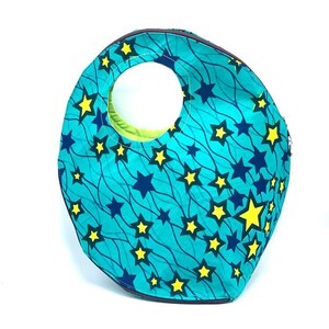 May include: A turquoise blue and yellow star patterned tote bag with a round opening and a zipper closure.
