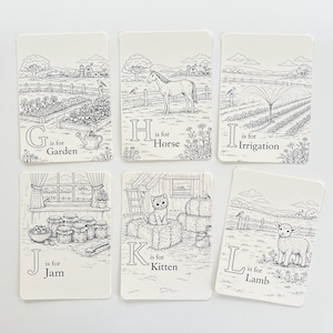 Peut inclure: Six cartes blanches avec des dessins au trait noirs de sc&egrave;nes de ferme et de lettres. Les cartes pr&eacute;sentent un jardin, un cheval, une irrigation, de la confiture, un chaton et un agneau. Chaque carte a une lettre et un mot : G pour Jardin, H pour Cheval, I pour Irrigation, J pour Confiture, K pour Chat et L pour Agneau.
