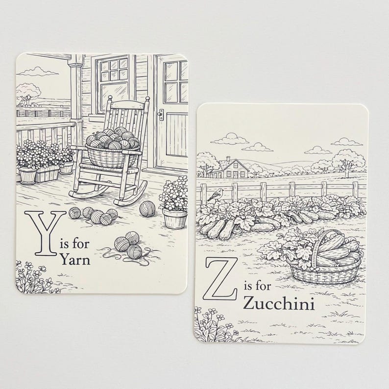 Peut inclure: Deux cartes illustr&eacute;es avec des dessins au trait noirs. L'une montre un porche avec une chaise &agrave; bascule et le texte "Y is for Yarn". L'autre repr&eacute;sente un jardin avec le texte "Z is for Zucchini".