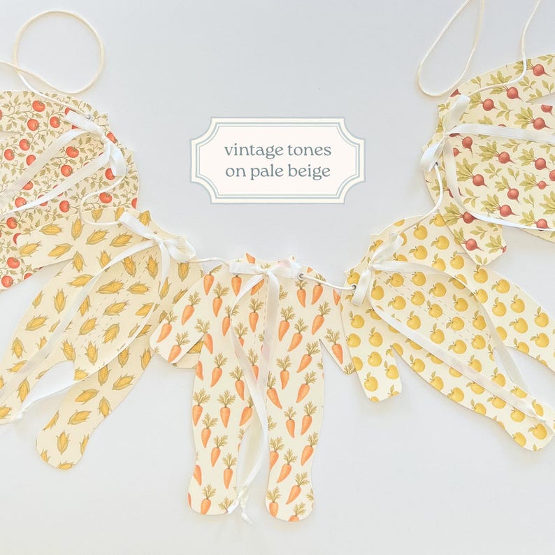 May include: A decorative banner with a vintage design. The banner features various shapes, including carrots, apples, and leaves, printed on a pale beige background. The text "vintage tones on pale beige" is displayed on a white label.