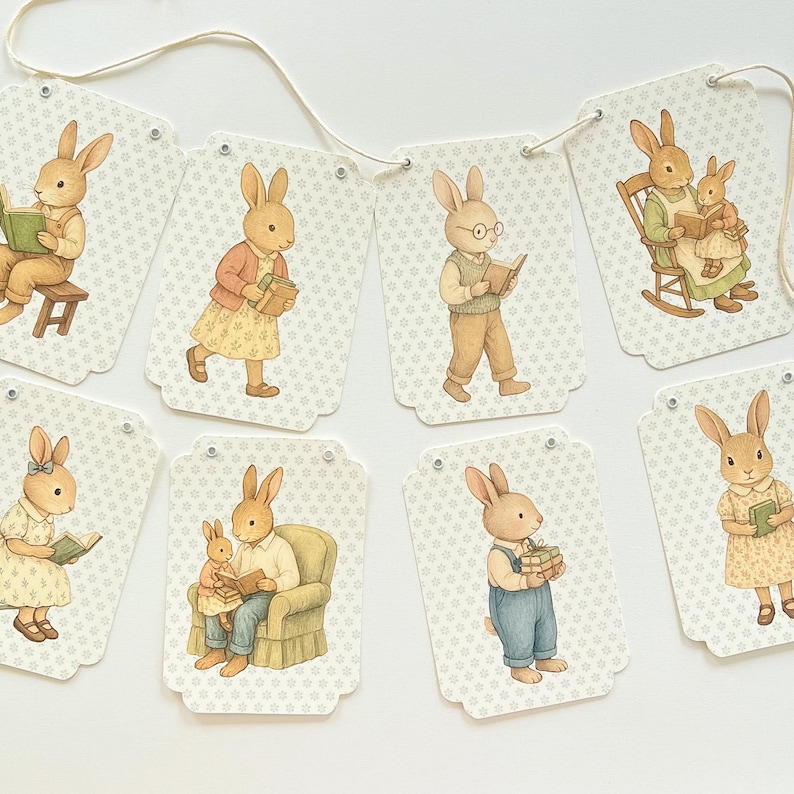 May include: A garland of decorative tags featuring watercolor illustrations of rabbits in various poses. The rabbits are depicted reading books, wearing clothes, and interacting with each other. The tags have a light beige background with a subtle floral pattern.