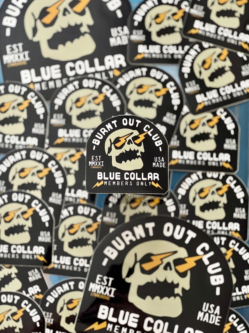May include: A collection of black and white stickers with a skull design. The skull has lightning bolts coming out of its eyes. The text on the stickers reads "Burnt Out Club" and "Blue Collar Members Only".
