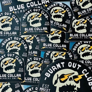 May include: A collection of black and white stickers with a skull graphic and the text "Burnt Out Club" and "Blue Collar Members Only".