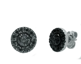 May include: A pair of round stud earrings featuring a cluster of small, faceted black stones set in a circular metal frame. The design includes a central group of stones surrounded by an outer ring of stones, with a post and butterfly back closure.