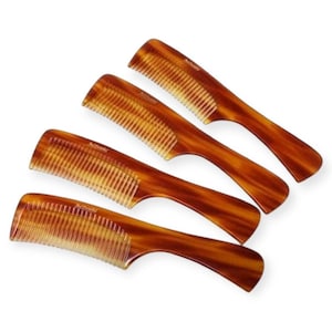 May include: Four brown tortoise shell combs with a curved handle and fine teeth. The combs are arranged in a stack, with the largest comb at the bottom and the smallest comb at the top.