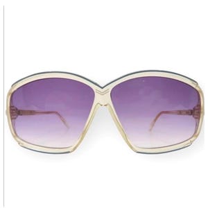 Può includere: Occhiali da sole vintage oversize con montatura color crema e lenti sfumate viola. Gli occhiali da sole hanno un design angolare unico e un'estetica retrò. Un accessorio elegante per la protezione solare.