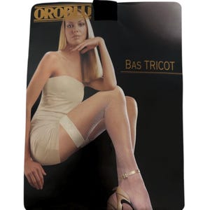 May include: White fishnet stockings with a white garter belt and a black background. The packaging has the text "OROBLU" and "BAS TRICOT".
