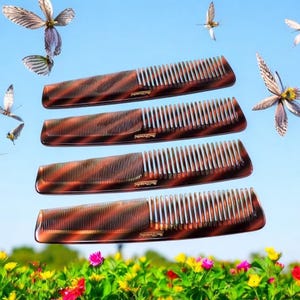 May include: Four brown tortoise shell combs with a curved shape and fine teeth. The combs are stacked on top of each other against a blue sky background with flowers in the foreground.