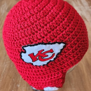 Casco da football ispirato ai Kansas City Chiefs. Casco fatto a mano all&#39;uncinetto, berretto invernale. Disponibile nelle taglie da neonato a XL per adulti.