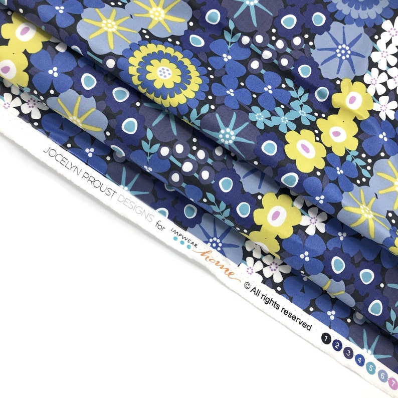 May include: Blue and yellow floral fabric with a repeating pattern of flowers and dots. The fabric is folded over and the label reads "Jocelyn Proust Designs for Impwear Home &copy; All rights reserved".