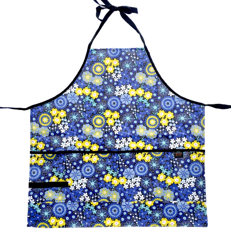 May include: A blue and yellow floral print apron with black trim and two pockets. The apron has adjustable neck straps.