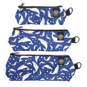 May include: Three blue zippered pouches with a white whale pattern and white polka dots. The pouches have black zippers and black handles. The pouches are labeled "Splash Fabric".
