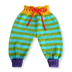 May include: Striped knitted baby pants with a yellow, green, and blue color scheme. The pants have a red drawstring and purple cuffs.