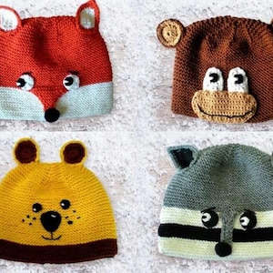 Może przedstawiać: Cztery dziane czapki z twarzami zwierząt. Czapki są czerwone, brązowe, żółte i szare. Każda czapka ma inną twarz zwierzęcia, w tym lisa, małpę, niedźwiedzia i szop.