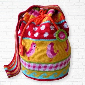 May include: A colourful crocheted drawstring bag with a long strap. The bag features a red, white and yellow striped pattern with a pink and green bird design.