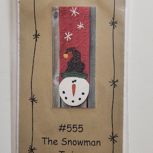 May include: A brown paper card with a red and white snowflake pattern, a snowman with a black hat and a carrot nose, and the text "Bloomin' Minds Half to Have #555 The Snowman Twins".