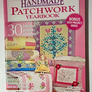 May include: A pink magazine cover with the title "Handmade Patchwork Yearbook" and a picture of a patchwork quilt with a tree design. The magazine cover also includes the text "Over 30 fabulous projects to create" and "Bonus 2010 Project Index".