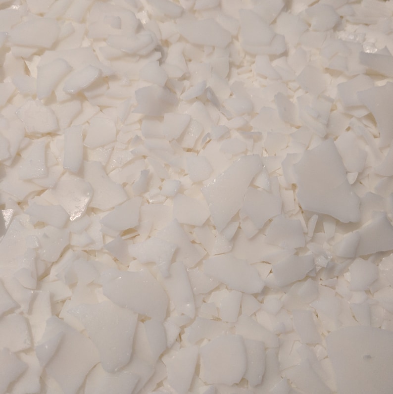 May include: Close-up of white, irregularly shaped flakes. The flakes are scattered across the frame, creating a textured surface. The color is a bright, clean white, suggesting a clean, pure material. The image is well-lit, highlighting the shapes and textures.