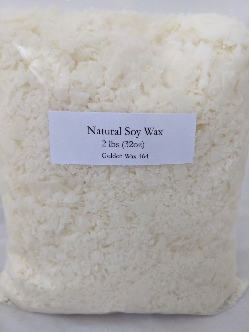 Pu&ograve; includere: Un sacchetto trasparente pieno di cera di soia a scaglie bianco sporco. Un'etichetta bianca sul sacchetto recita "Natural Soy Wax" e "2 lbs (32oz)" con "Golden Wax 464" sotto. La cera ha forme irregolari.