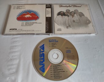 May include: A CD case with a gold CD inside. The front of the case features a photo of the band Grateful Dead. The back of the case lists the songs on the CD, including "Go To Heaven", "Alabama Getaway", "Feel Like a Stranger", "Lost Sailor", "Saint of Circumstance", "Antwerp's Placebo (The Plumber)", "Easy to Love You", "Don't Ease Me In", and "The Grateful Dead".