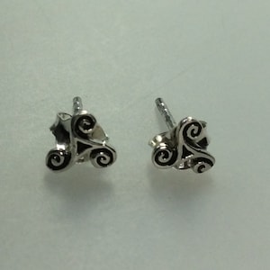 May include: A pair of silver stud earrings with a black Celtic knot design.