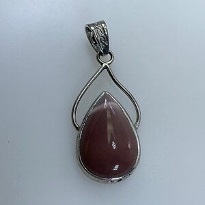 May include: A silver pendant with a teardrop-shaped pink and white gemstone.
