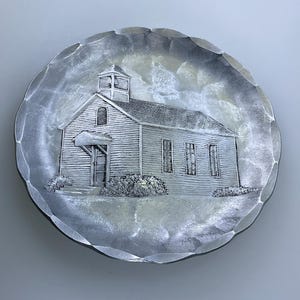 May include: A silver metal plate with a raised design of a small white church building with a steeple.