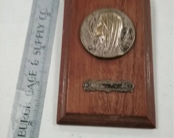 Vintage used religious medal on plaque
