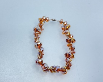 May include: A brown crystal beaded bracelet with a silver clasp.