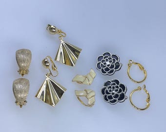 Può includere: Una collezione di orecchini vintage in vari stili. Include orecchini a clip a forma di ventaglio color oro, orecchini a clip color oro strutturati, orecchini a clip a forma di fiore neri e argentati, orecchini a clip a forma di fiocco color crema e oro e orecchini a cerchio dorati.