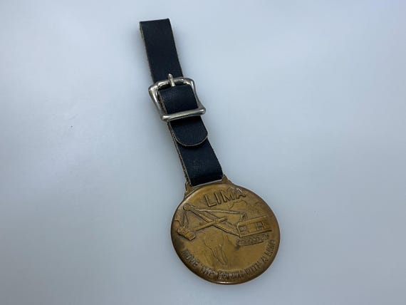 Vintage Lima Watch Fob Brass Toned Round Earth Mover Highway Equipment Company Pittsburgh Pennsylvania Black Strap Used