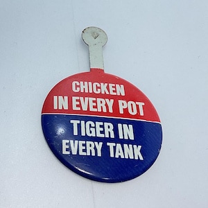 May include: A red and blue round button with a white pin. The button says "Chicken in every pot Tiger in every tank".