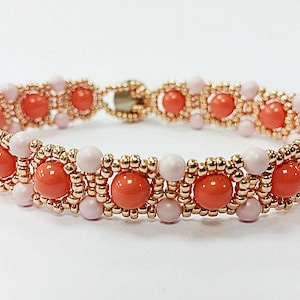 May include: A beaded bracelet with alternating pink and orange beads. The bracelet is made with small gold beads and larger round beads.