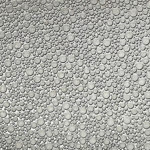 May include: A close-up view of a textured, gray surface covered in a pattern of raised, circular shapes of varying sizes. The circles are densely packed, creating a bubbly or cellular appearance. The lighting highlights the texture.