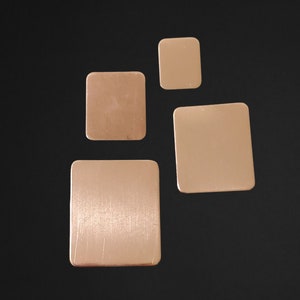 May include: Four square copper coasters in different sizes. The coasters are all a light copper color and have a smooth, polished finish.